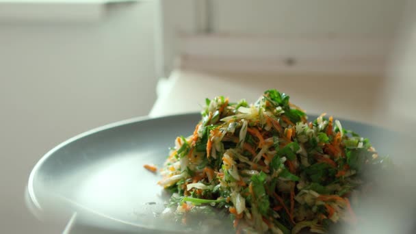 El hombre pone ensalada vegetariana fresca en un plato . — Vídeos de Stock