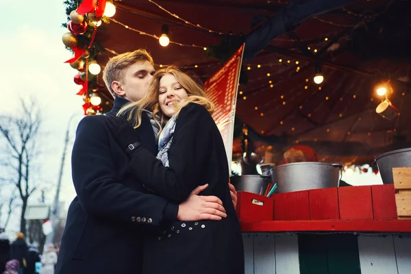 Elegante coppia romantica innamorata abbracciare e baciare su rosso brillante decorazioni festive sfondo. — Foto Stock