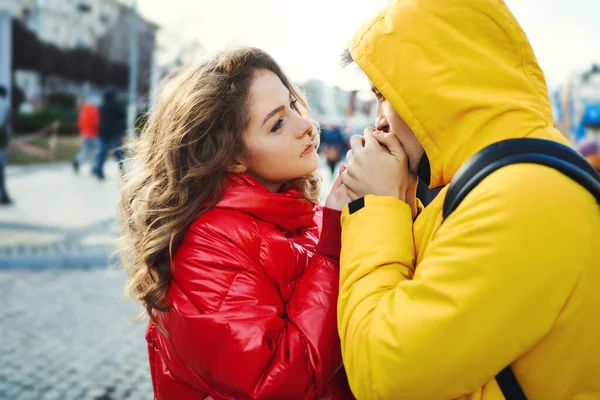 Close-up retrato jovem casal romântico ternamente olhando um para o outro, jovem homem ternamente aquece as mãos sua namorada. — Fotografia de Stock