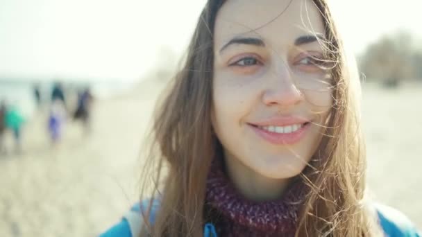 Крупным планом портрет привлекательной улыбающейся юной брюнетки на открытом воздухе — стоковое видео