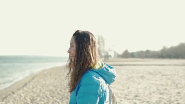 Mujer caminando al aire libre en la playa de arena de mar en el día soleado viento soplando pelo — Vídeos de Stock