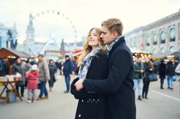 Elegante coppia romantica innamorata abbracciare e baciare per strada con attrazione sullo sfondo. — Foto Stock