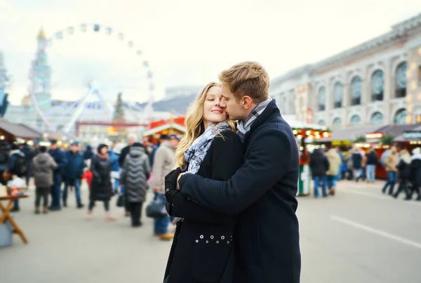 Retrato de la pareja elegante en el amor abrazando y besando en la calle con atracción en segundo plano.. —  Fotos de Stock