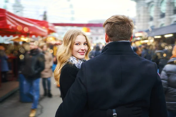 Elegante pareja romántica caminando calle de la ciudad en una multitud de personas. atractiva mujer rubia dar la vuelta y mirando a la cámara . —  Fotos de Stock