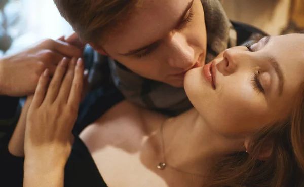 Close-up retrato de bela mulher loira com olhos fechados, homem bonito ternamente beijando sua namorada — Fotografia de Stock