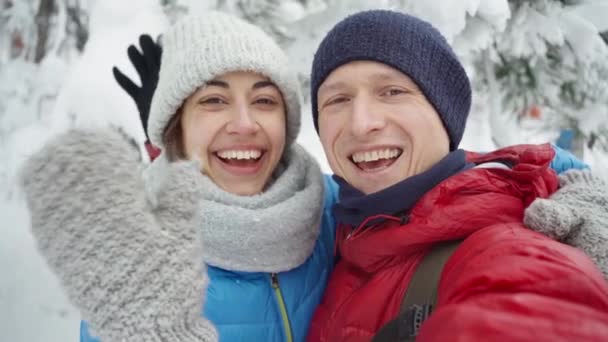 Jovem casal andando no parque de inverno nevado no dia de inverno frio. homem e mulher adorável abraçando beijando e rindo . — Vídeo de Stock