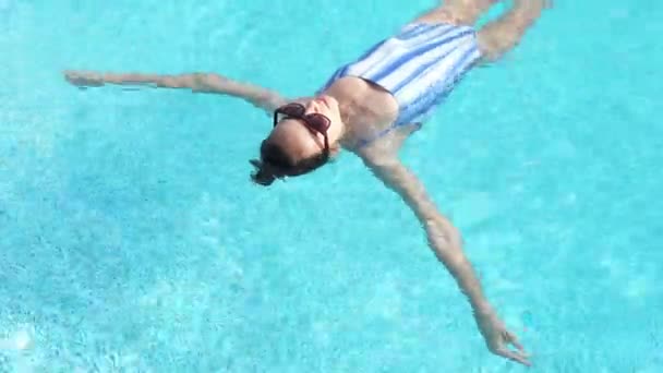 Blick von oben Schöne Frau schwimmt auf dem Rücken im Schwimmbad im Luxushotel Spa — Stockvideo