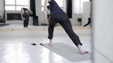 İçeride yoga yapan bir grup genç sporcu. Öndeki yakışıklı adam..