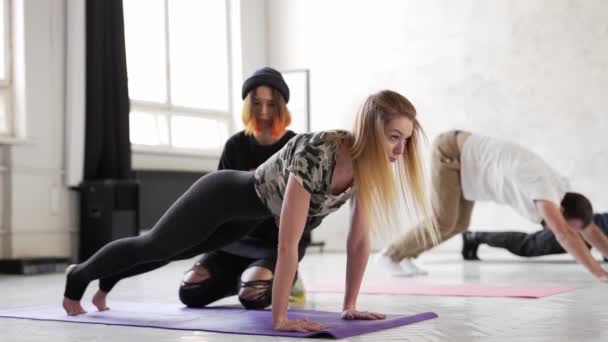 Гнучка фітнес-леді, що практикує йогу, стоїть у дощатій позі — стокове відео