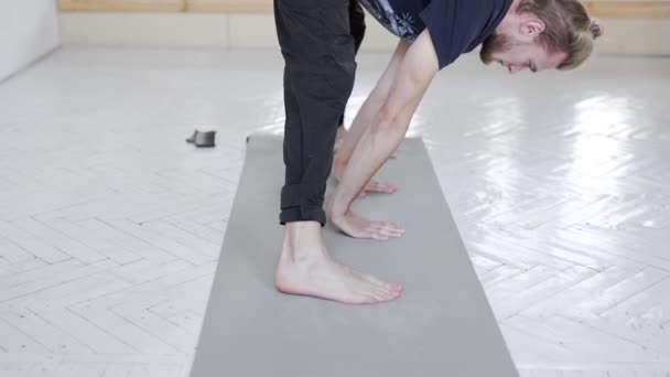 Slow motion jonge knappe man oefenen yoga in licht yoga klasse — Stockvideo