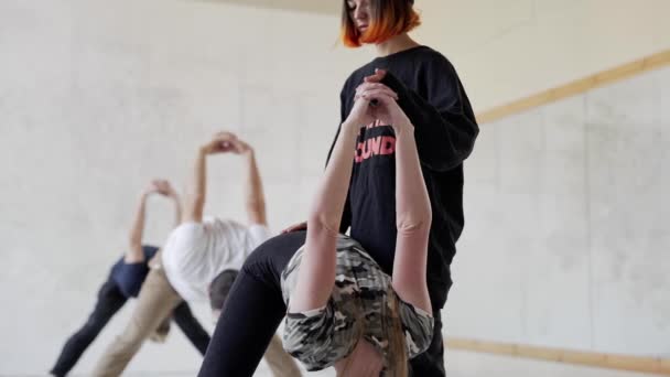 Αργής κίνησης νέοι άνθρωποι της ομάδας στην τάξη γιόγκα πρακτική γιόγκα και να κάνει ασκήσεις τεντώματος για τα πόδια και την πλάτη. — Αρχείο Βίντεο