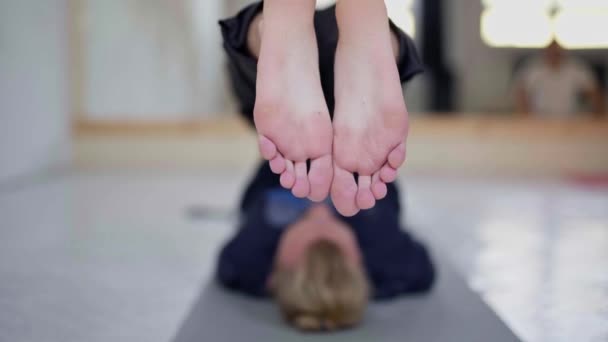 Zeitlupe junger, unkenntlich gemachter Mann praktiziert Yoga im leichten Yoga-Kurs — Stockvideo