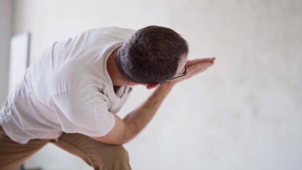 Back view s of sporty man practicing yoga in yoga class, making stretching back. — Stock Video