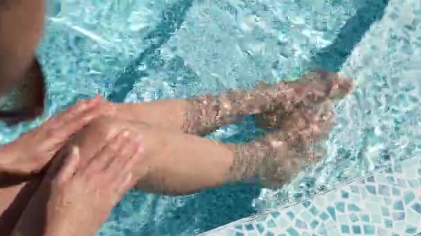 高級ホテルのスパでスイミングプールでリラックスした認識できない女性のトップビューの足 — ストック動画