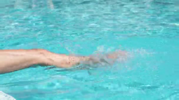 Piernas femeninas inmersas en agua en la piscina — Vídeos de Stock