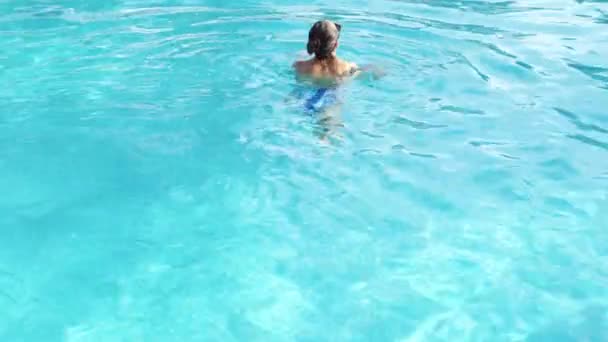 Schöne Frau schwimmt auf dem Rücken im Schwimmbad im Wellness-Bereich des Luxushotels — Stockvideo