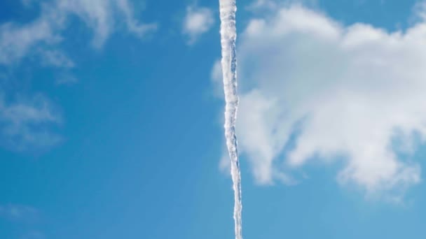 巨大的长冰柱映衬着明亮的蓝天，白云密布 — 图库视频影像