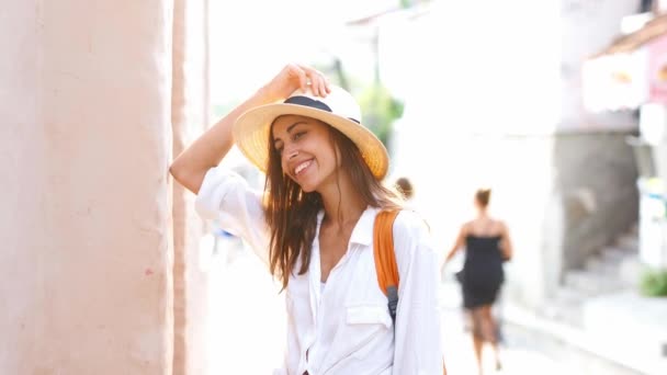 Retrato hermosa mujer turista en sombrero de paja, camisa blanca posando y sonriendo a la cámara — Vídeos de Stock