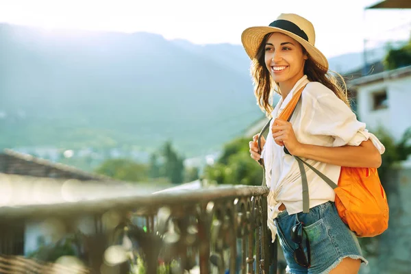 Ritratto bella donna turistica in piedi sul punto di vista con le montagne e la luce del sole su bakcground, esplorare la strada della città . — Foto Stock