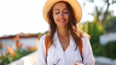 Beyaz gömlekli ve saman şapkalı çekici bir turist. Güzel gülüşler güneş gözlüğü takıyor.