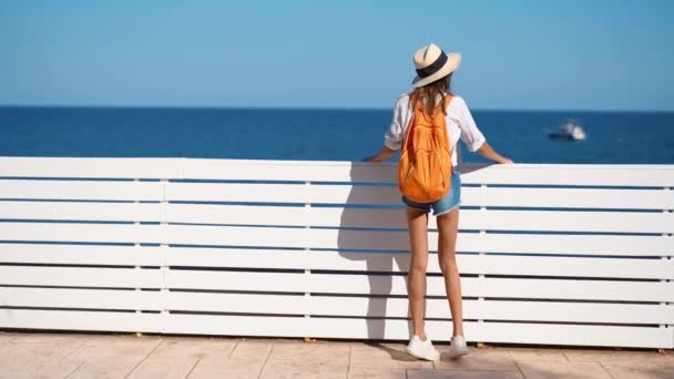 Slow motion bela mulher turista em sunhat, camisa e shorts desfrutando vista mar — Vídeo de Stock