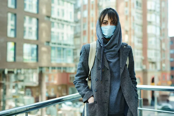 stock image Woman in city street with building on background, standing in protection face mask for prevention coronavirus.