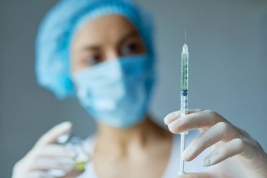 Şırınga, aşı, tıbbi enjeksiyon, eldiven içinde şişe. Kadın doktor arka planda bulanıklık.