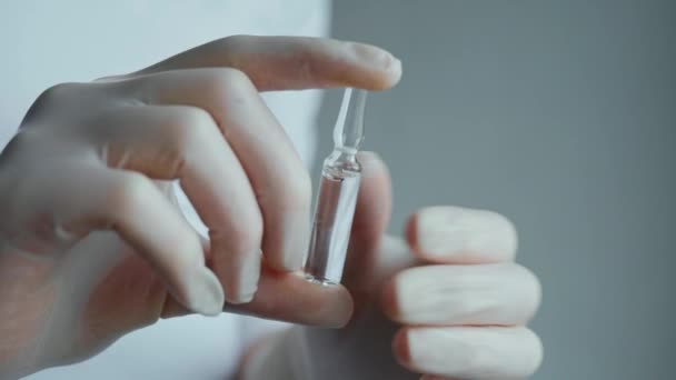 Le médecin tient une ampoule avec un médicament dans les mains et l'ouvre . — Video