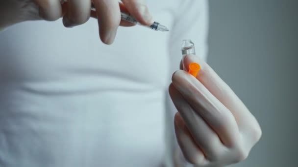 Vaccin injectieflacon, fles in handen in handschoenen. arts of wetenschapper in laboratorium wazig op achtergrond. — Stockvideo