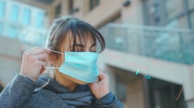 Virüsü korumak için tıbbi maske takan genç bir kadın. Konsept koronavirüs salgını, SARS, MERS, COVID-19, karantina, izolasyon süresi.