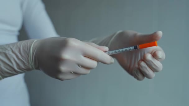 インスリン針注射器 白い滅菌保護手袋のクローズアップ看護師の手は注射針からキャップを離陸します 針付き工具 — ストック動画