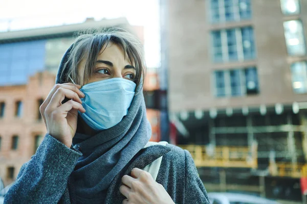都市のコロナウイルスのパンデミック フードを身に着けている女性の顔のマスク予防コロナウイルスのための 背景に建物と街の通りに立って — ストック写真