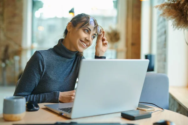 Attractive Pleased Woman Sitting Desk Laptop Looking Away Smiling While — Stock Photo, Image