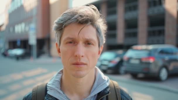 Close-up adult gray hair man looking straight to camera on empty street and urban background — Stock Video