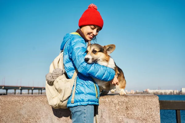 微笑的女孩在户外和她的狗在一起 可爱的年轻女子在春日的艳阳天爱抚和拥抱可爱的科吉犬 — 图库照片