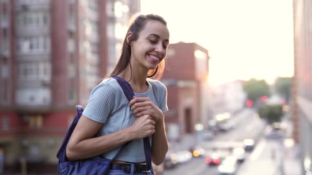 SLOW MIION: счастливая улыбающаяся молодая девушка в повседневной одежде на улице — стоковое видео