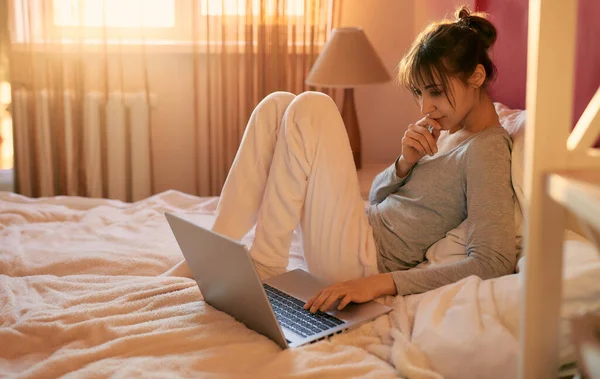 Nuori Nainen Pyjamassa Kannettavan Tietokoneen Avulla Rentoutuen Sängyssä Kotona Auringonvalo — kuvapankkivalokuva