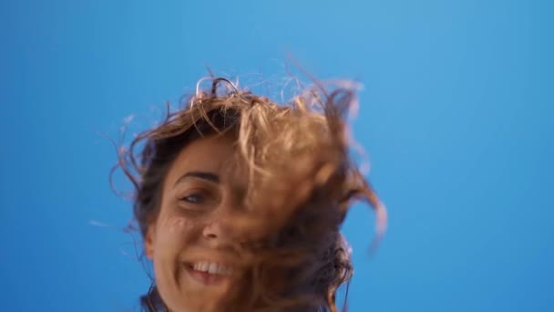 Super slow motion close up retrato de jovem alegre menina tremendo voando cabelo, olhando para baixo para a câmera e sorrindo — Vídeo de Stock