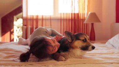 Sevdiği köpeği Galli Corgi ile yatakta yatan mutlu kadının yakın plan portresi..