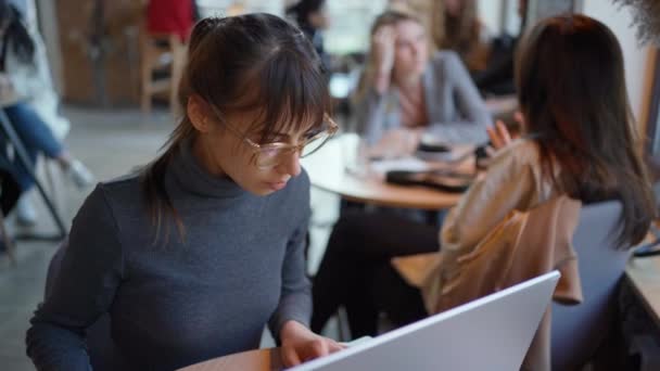 Attraktiv kvinnlig entreprenör som arbetar med bärbar dator på kafé eller coworking. — Stockvideo