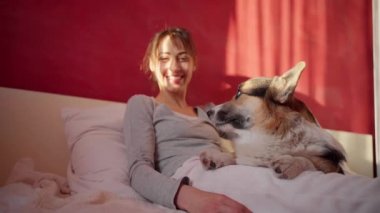 Mutlu bir kadın ve evde sevimli bir Corgi köpeği var.