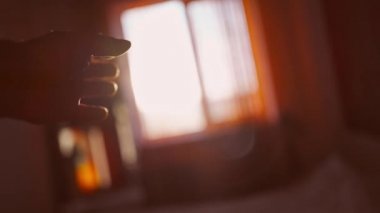 POV yakın çekim erkek eli güneş ile oynuyor ve pencereye doğru yükseliyor.