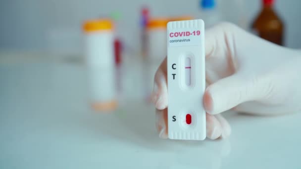 Primer plano laboratorio científico manos en guantes celebración prueba para COVID-19 analizar . — Vídeo de stock