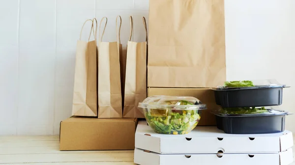 Different paper packages and containers for takeaway food on table. Takeout meal, deivery to home. — Stock Photo, Image