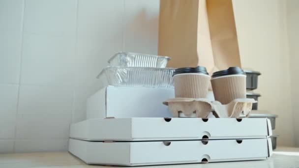 Muitos outros pacotes de papel e recipientes para comida takeaway na mesa wiht fundo branco . — Vídeo de Stock