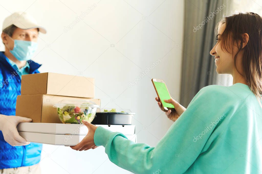 woman receiving packages from delivery man. Delivery food service at home, shopping order online from smartphone