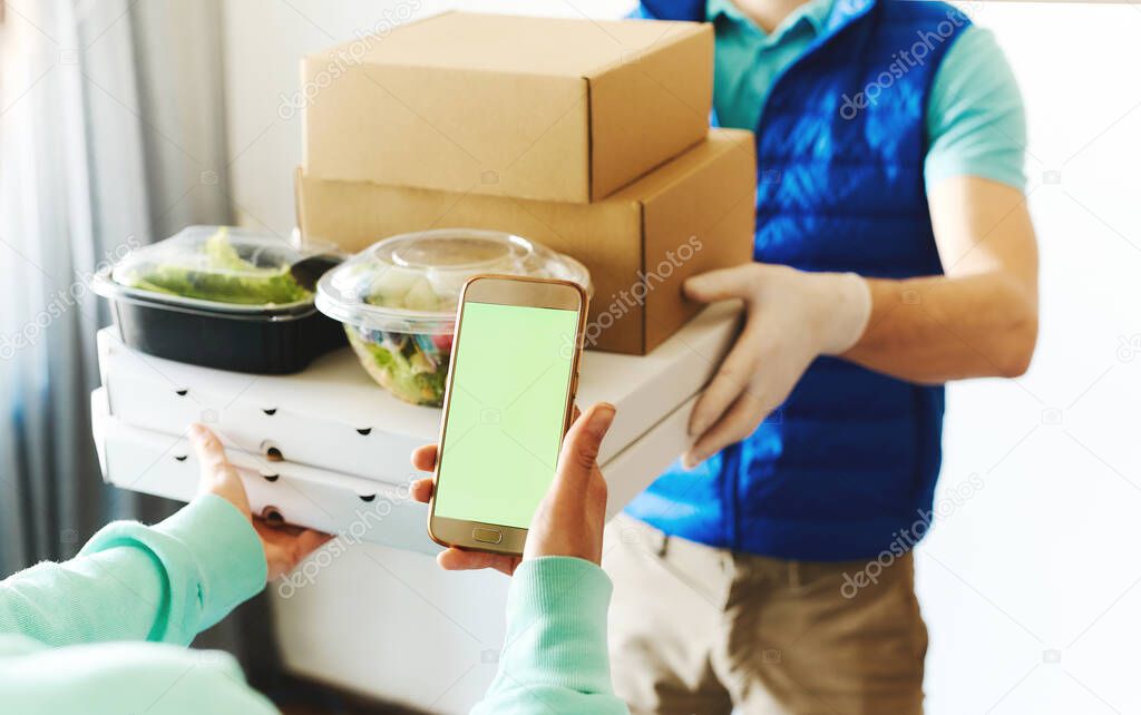 POV of woman using smarthone for ordering online, receiving takeout food from delivery man.