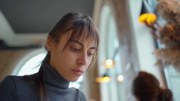 Soustředěná žena používající notebook pracující v kavárně, vzdálená práce. — Stock video