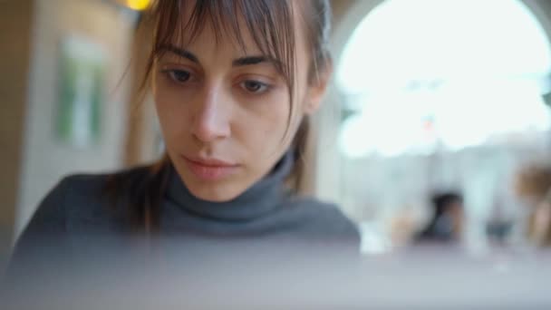 Closeup συμπυκνωμένη γυναίκα φοιτητής ή ελεύθερος επαγγελματίας χρησιμοποιώντας φορητό υπολογιστή στο cafeshop — Αρχείο Βίντεο