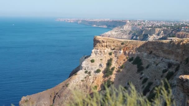 Úžasné panorama pobřežní krajiny s vysokým vápencovým útesem nad modrým mořem a jasnou hlubokou modrou oblohou — Stock video